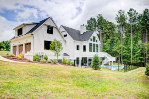 A large white house with a pool in the yard.