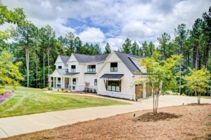 A large white house with trees in the background.