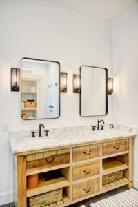 A bathroom with two mirrors and a double sink.
