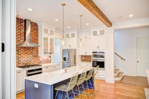 A kitchen with white cabinets and wooden floors.