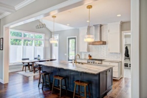 A kitchen with a large island and wooden floors.