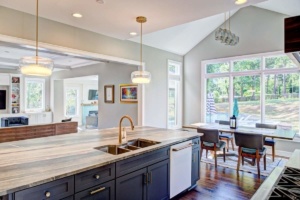 A kitchen with a sink, dishwasher and dining room table.