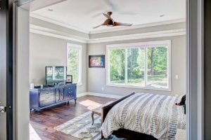 A bedroom with a bed, dresser and tv.