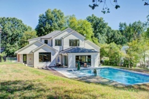 A house with a pool and trees in the background