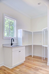 A kitchen with white cabinets and a sink.