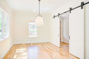 A room with hard wood floors and white walls.