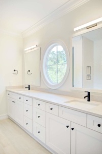 A bathroom with two sinks and a large mirror.