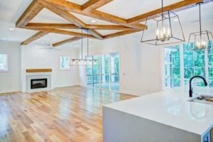 A large open living room with wood floors and beams.