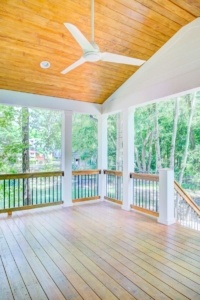 A porch with wood floors and white walls.