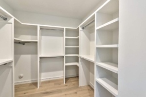 A large white closet with many shelves and hangers.