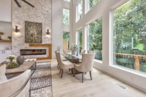 A dining room with large windows and a fireplace.