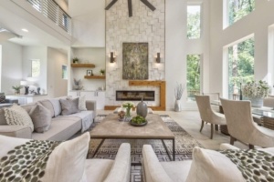 A living room with two large windows and a fireplace.