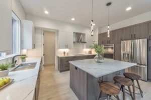 A kitchen with a large island and white cabinets.