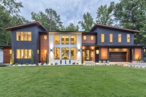 A large house with lots of windows and grass.