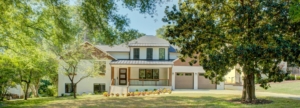 A large white house with a garage in the front yard.