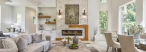 A living room with a fireplace and a painting on the wall.
