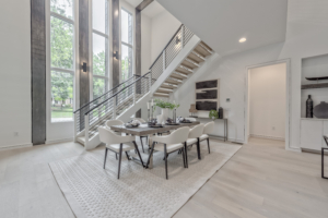 A dining room with stairs leading to the top floor.