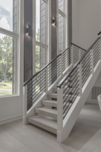 A white staircase with metal railing in the middle of it.