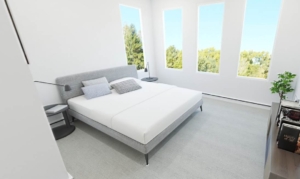 A bedroom with two large windows and a bed.