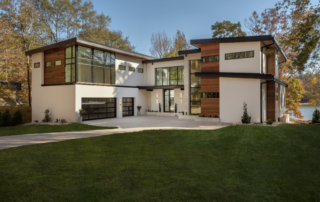 Modern contemporary home during day with white hard coat stucco walls, cumaru wood, floor to ceiling windows