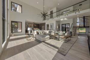 A large living room with a high ceiling and white furniture.