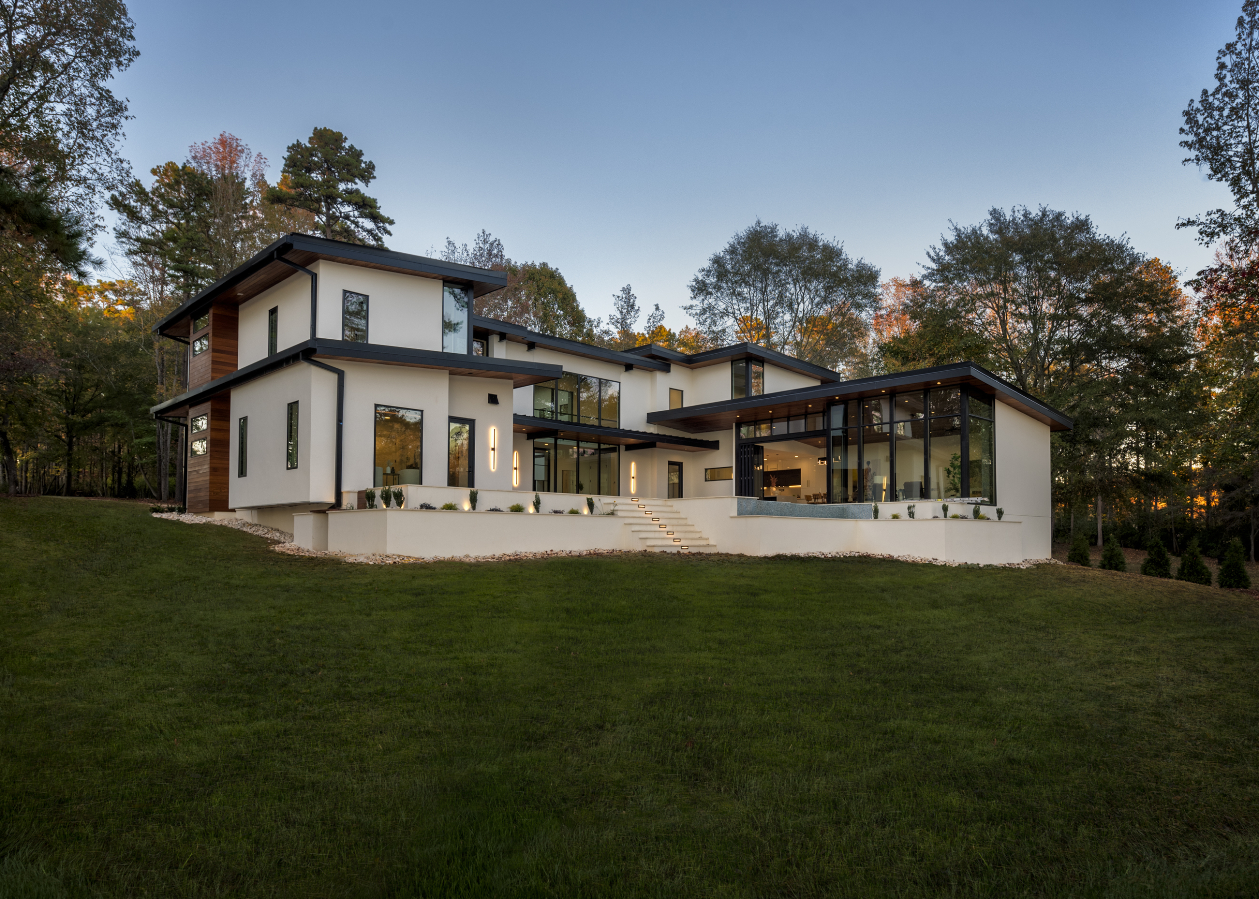 A large white house sitting on top of a green hill.