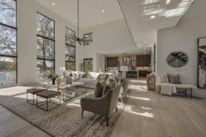A living room filled with furniture and large windows.