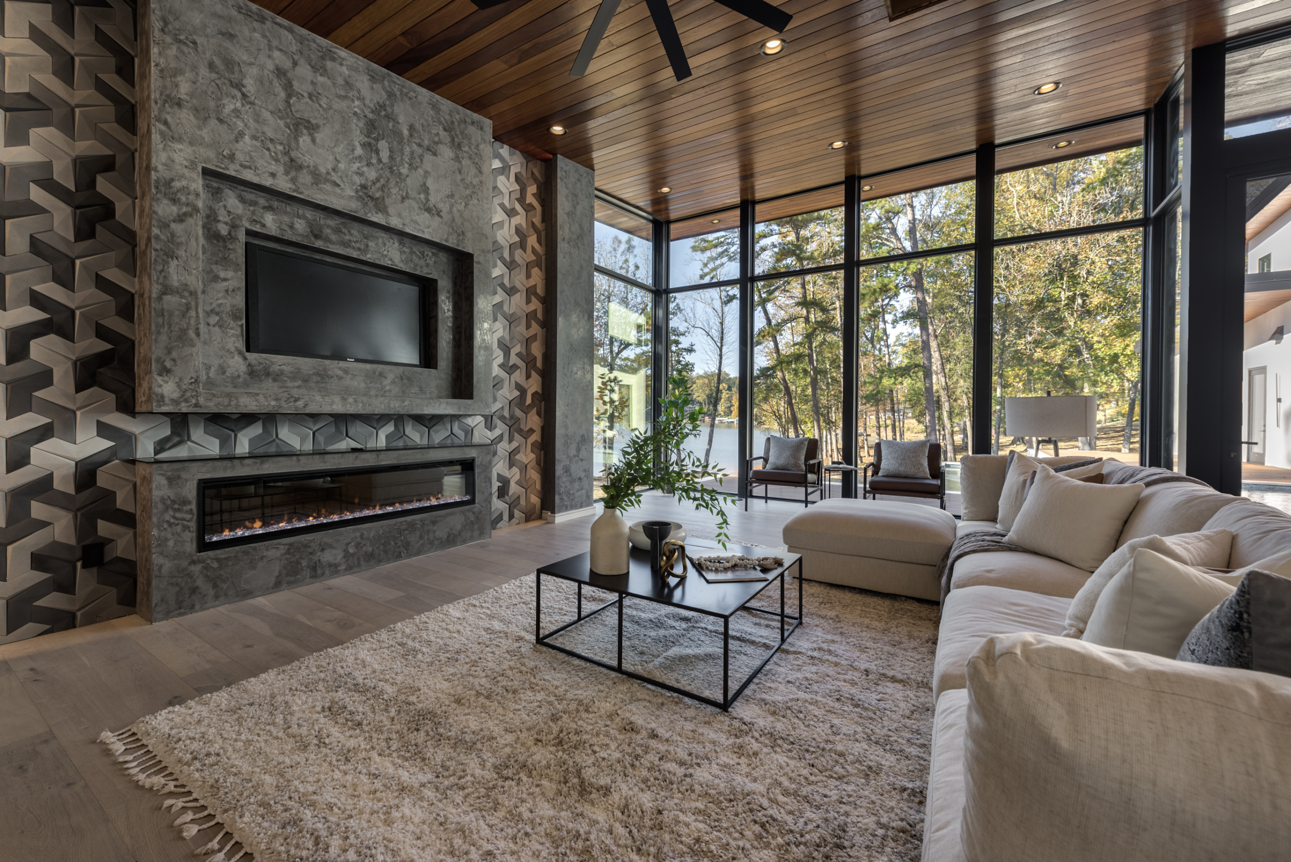 Contemporary living room with wood cumaru ceiling and floor to ceiling windows, with custom white palimanan limestone from Bali, Indonesia, with electric fire place