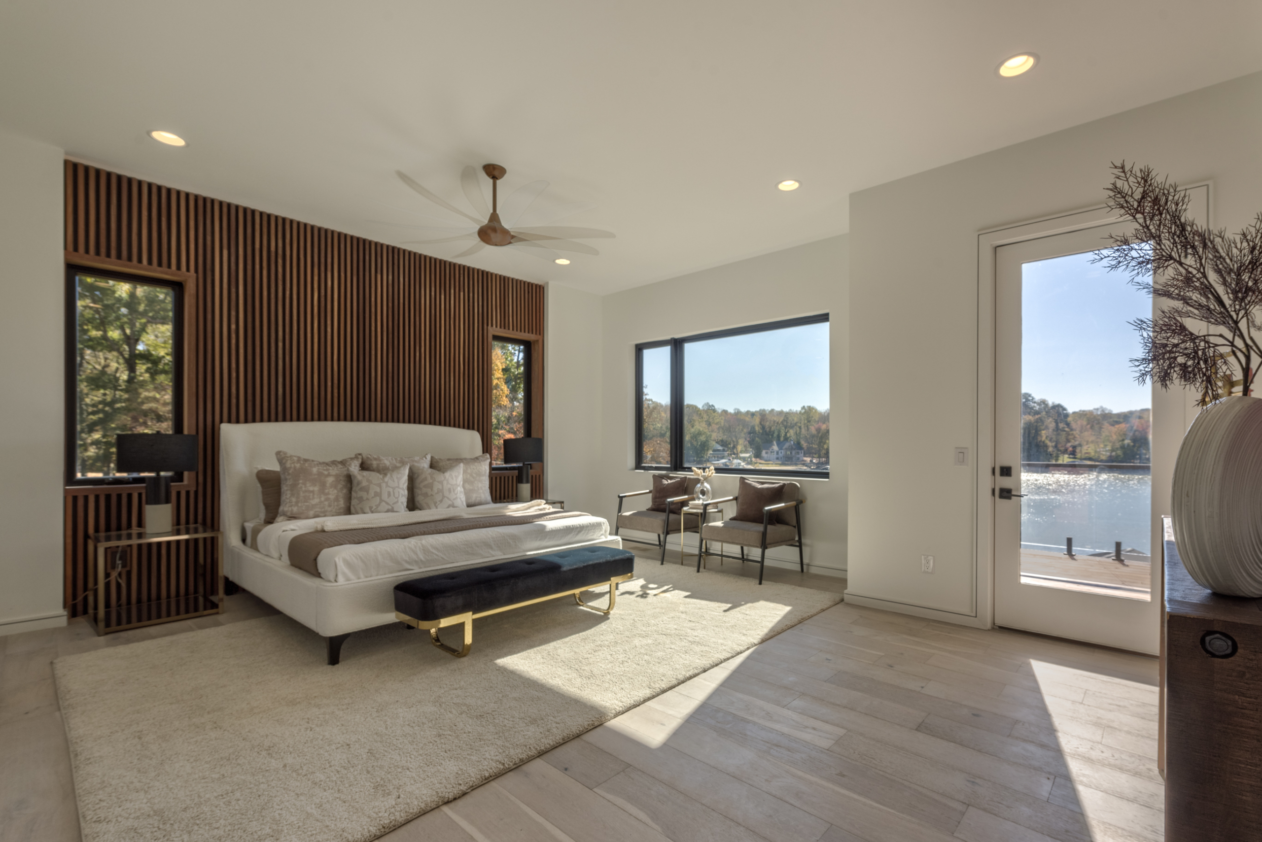Bedroom with outdoor access, seating area, and cumaru wood detail wall
