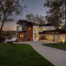 A large modern home with a lake in the background.