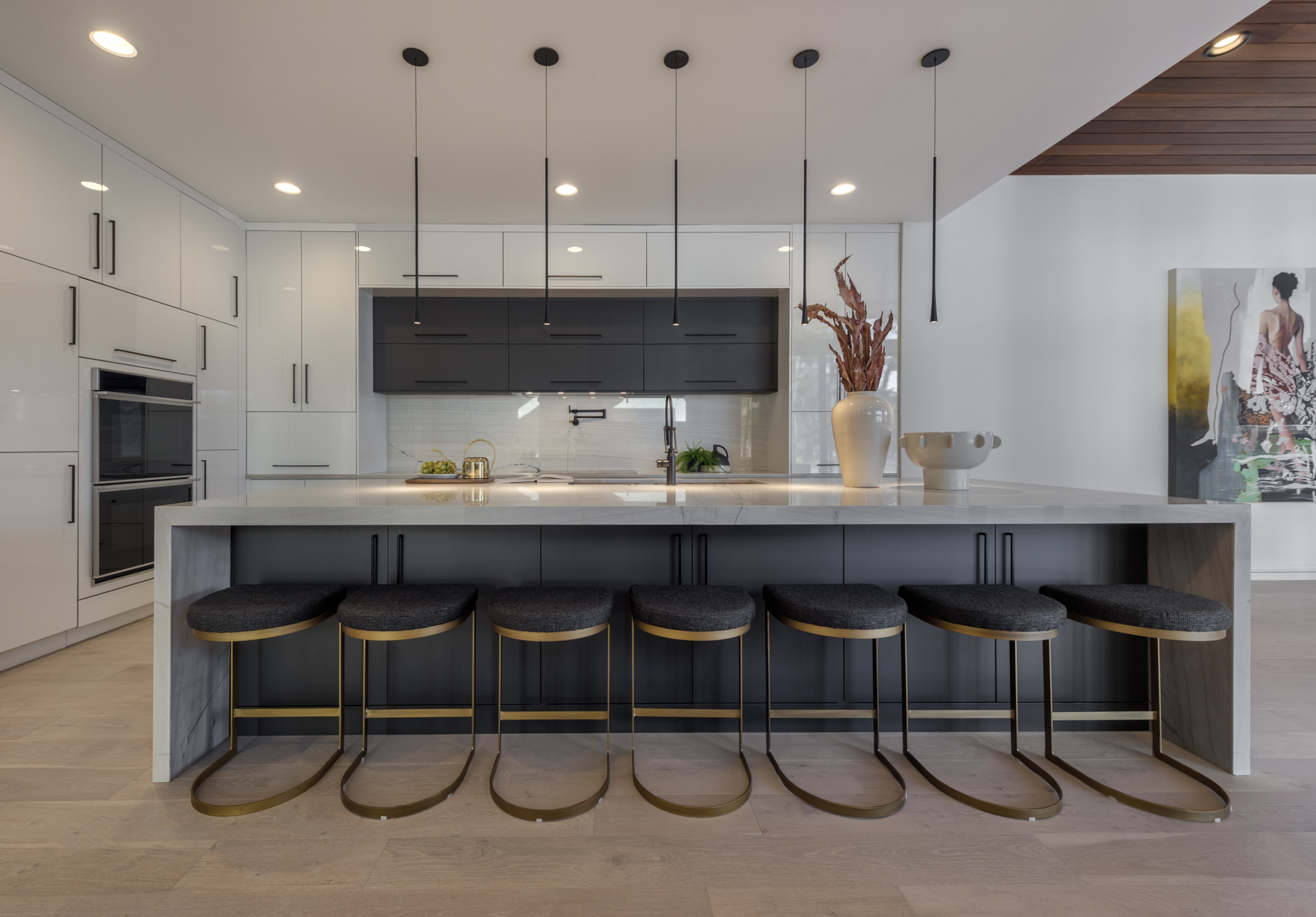 A kitchen with a large counter and lots of stools.