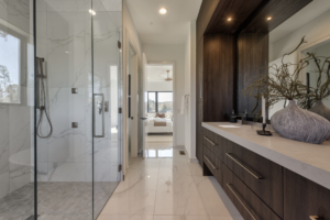 A bathroom with a large walk in shower and a double sink.