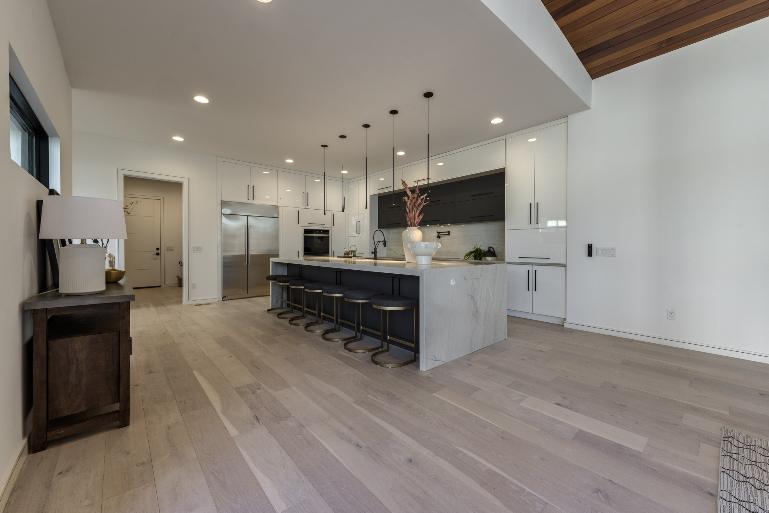 A kitchen with white walls and wooden floors.