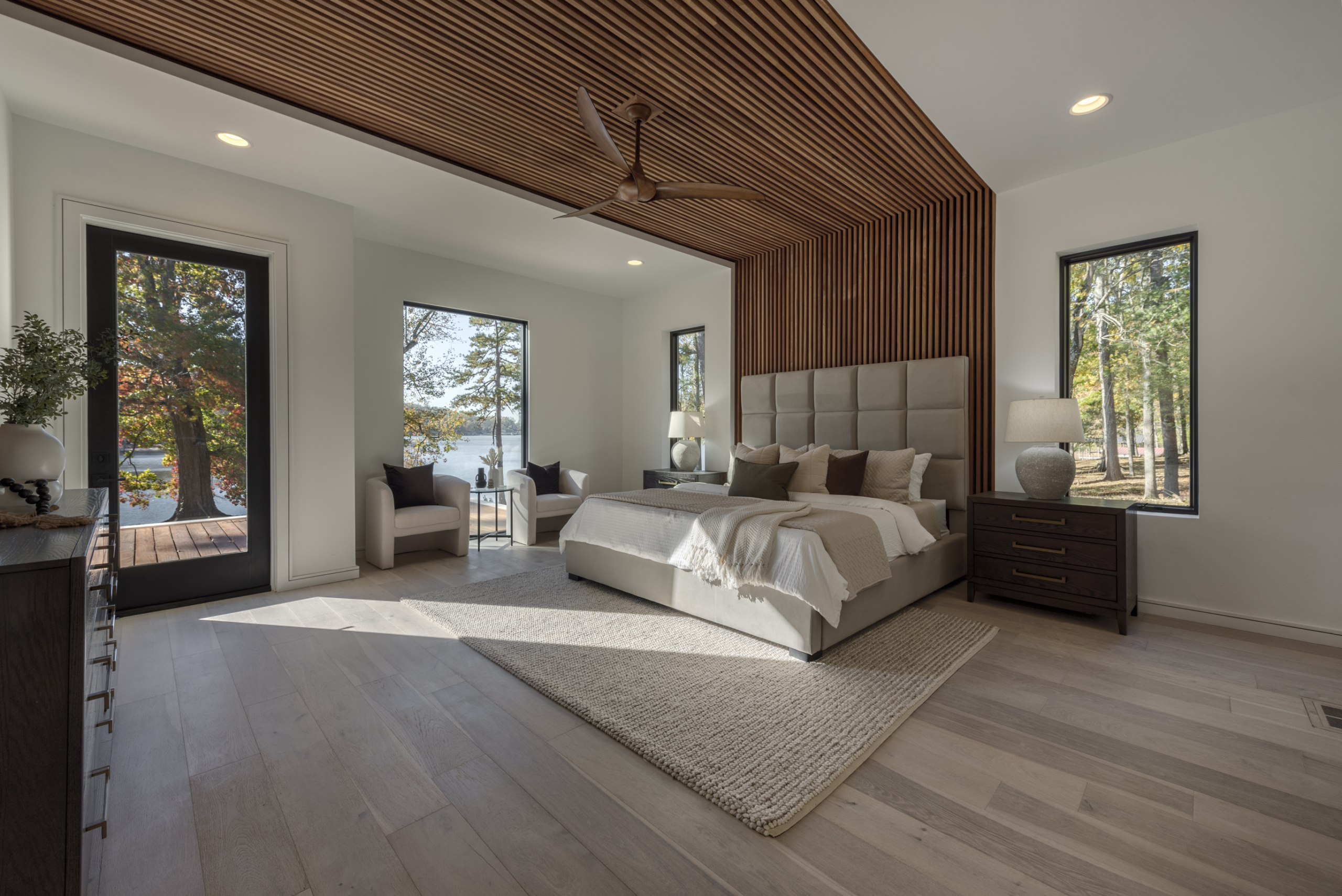 Modern primary bedroom with recessed LED linear lighting and cumaru wood wall and ceiling detail, Floor to ceiling windows, European white oak wood floors