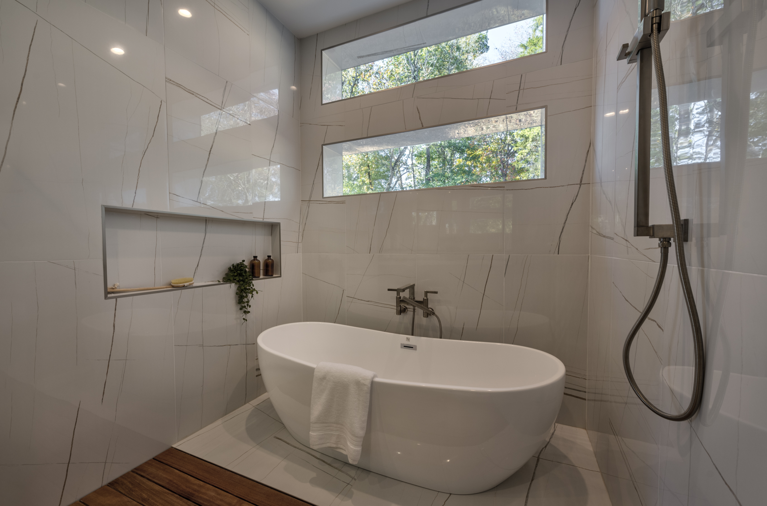 Modern Resort-style primary bath with freestanding tub and windows