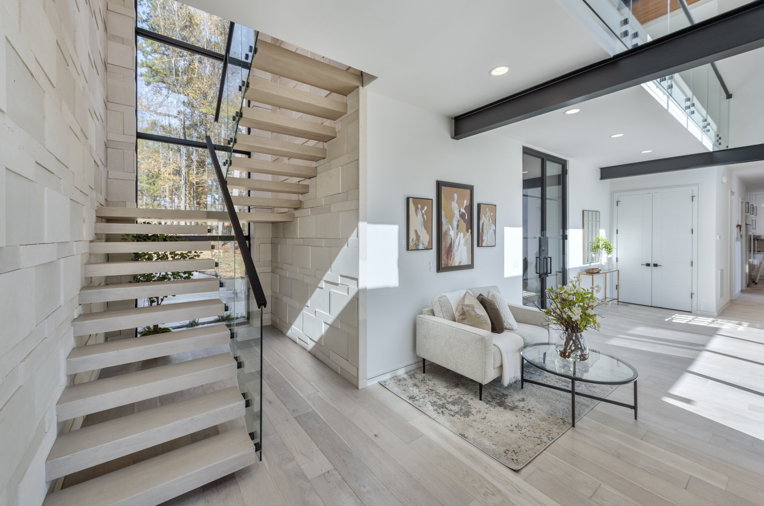 True free floating staircase cantilevered directly out of a palimanan limestone wall with all glass railing and floor to ceiling windows. 6’ wide x 10’ tall wrought iron and glass French front door