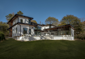 A large white house with a green lawn in front of it.