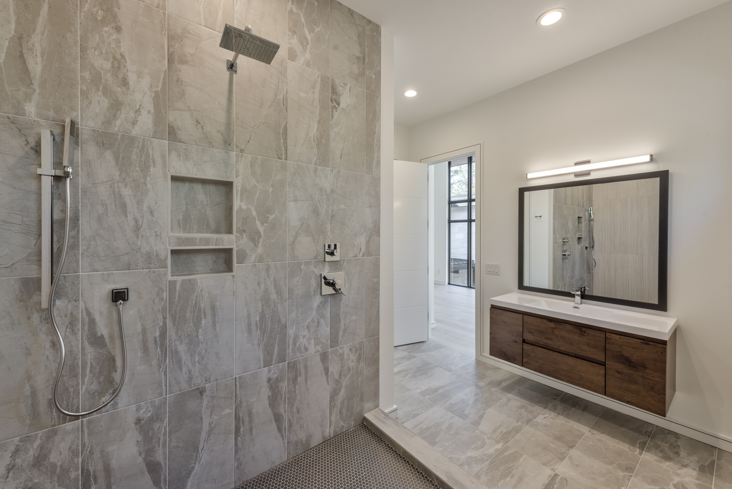 A large bathroom with marble walls and floors.