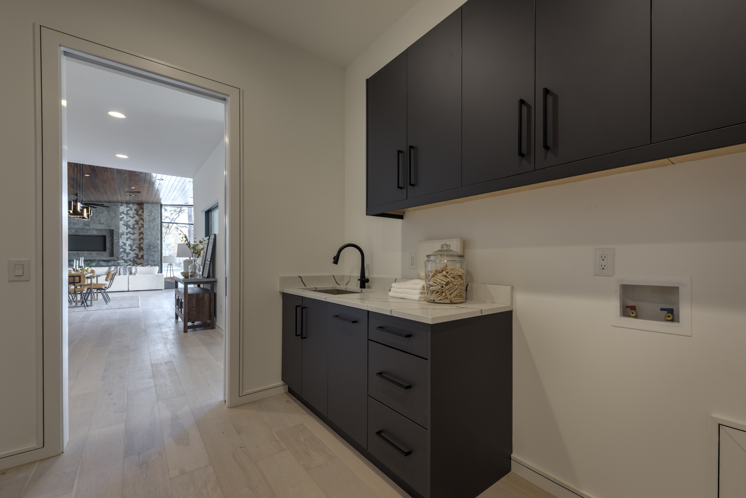 A kitchen with black cabinets and white counter tops.