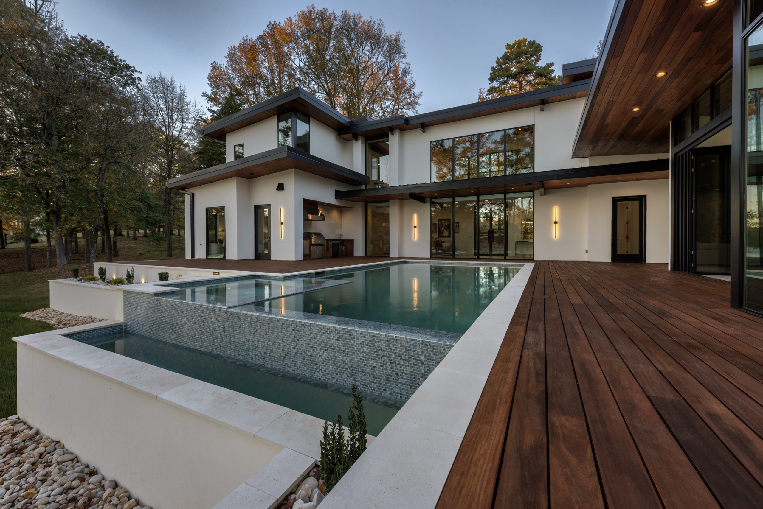 A large pool with a wooden deck in front of it.