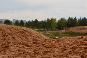 A dirt road with trees in the background