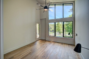 A large open living room with two windows.