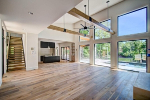 A large open floor plan with wood floors and windows.