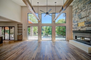 A large open living room with wood floors and windows.