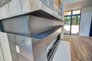 A fireplace with metal frame and concrete hearth.