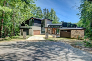 A large modern style house with a driveway.