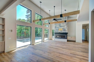 A large open living room with wood floors and windows.