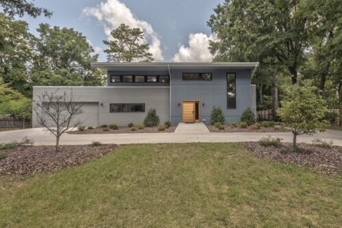 A large modern house with a grassy lawn.