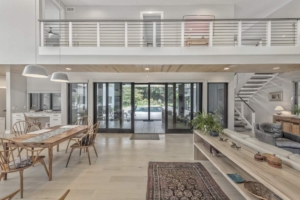 A large open living room with a pool in the background.
