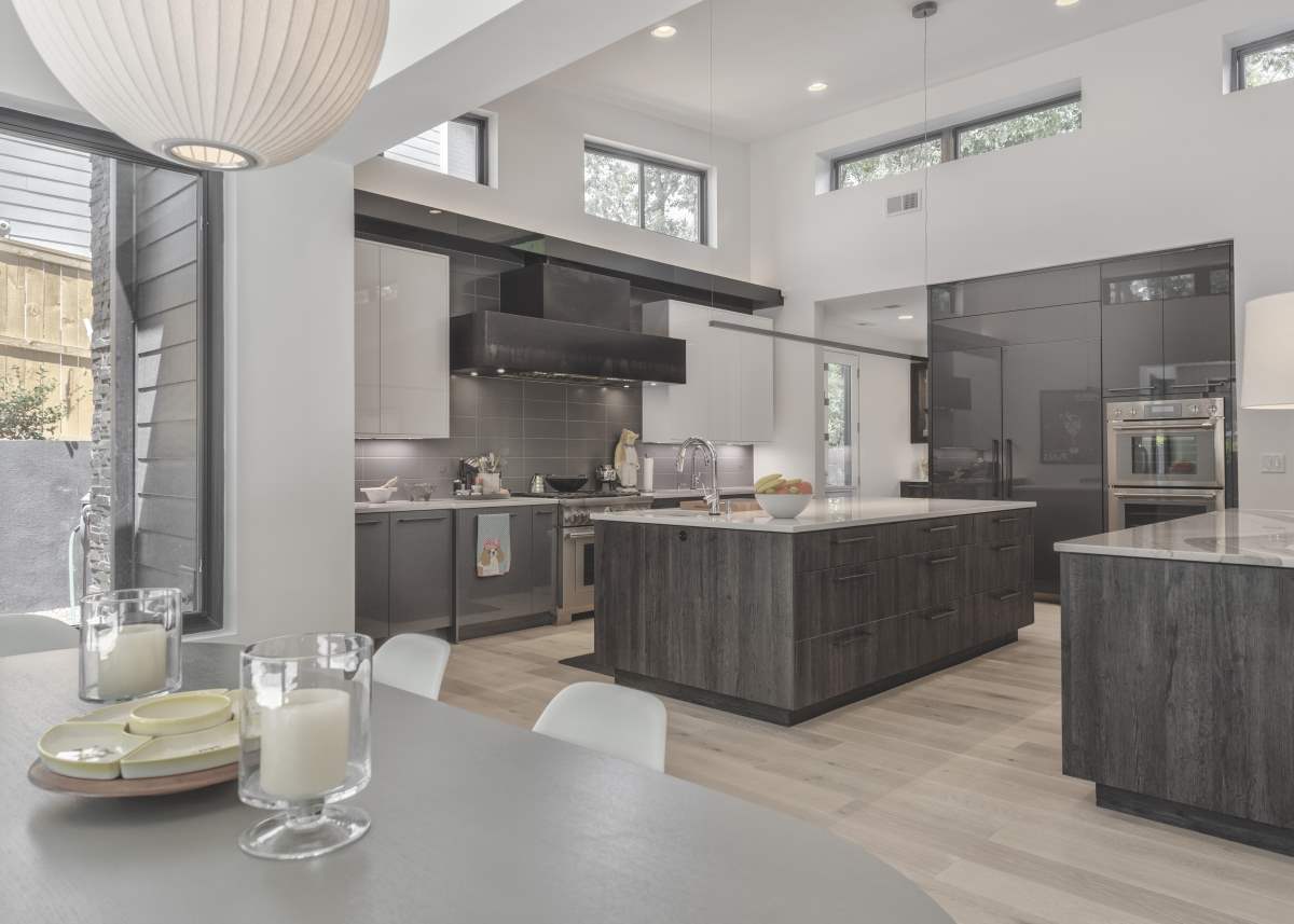 A kitchen with grey cabinets and white counters.